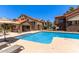 Community pool surrounded by lounge chairs, umbrellas, and multi-story buildings at 1905 E University Dr # 139, Tempe, AZ 85288