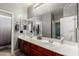 Bathroom with double sinks, a large mirror, and modern fixtures at 19415 W Colter St, Litchfield Park, AZ 85340