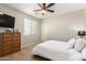 Bright bedroom with a white bed, dresser, and a large window for natural light at 19415 W Colter St, Litchfield Park, AZ 85340