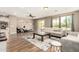 Modern living room featuring hardwood floors, a ceiling fan, and a sliding door leading to the outdoors at 19415 W Colter St, Litchfield Park, AZ 85340
