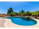 Private backyard oasis features a sparkling pool, spa, and mature palm trees, perfect for relaxation and entertaining at 19415 W Colter St, Litchfield Park, AZ 85340