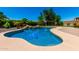 Beautiful pool with rock features and lush landscaping, creating a serene backyard oasis for relaxation and enjoyment at 19415 W Colter St, Litchfield Park, AZ 85340