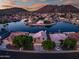 Aerial view of a neighborhood featuring waterfront homes and mountain views at twilight at 20657 N 56Th Ave, Glendale, AZ 85308
