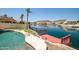 Beautiful backyard with a waterfront view, a pool with rock features, and a private dock for enjoying water activities at 20657 N 56Th Ave, Glendale, AZ 85308