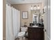 Functional bathroom featuring a sink, vanity, framed mirror, toilet, and a shower with a neutral colored shower curtain at 20657 N 56Th Ave, Glendale, AZ 85308
