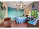 Coastal-themed bedroom featuring a ceiling fan, a nautical-inspired wall mural, cozy seating, and ample natural light at 20657 N 56Th Ave, Glendale, AZ 85308