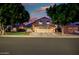 Two-story home boasting a three-car garage, arched windows, and well-manicured trees at twilight at 20657 N 56Th Ave, Glendale, AZ 85308