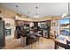 View of a kitchen featuring an island with stools, black countertops, and stainless steel appliances at 20657 N 56Th Ave, Glendale, AZ 85308