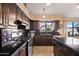 View of a kitchen featuring dark wood cabinets, granite countertops, and stainless steel appliances at 20657 N 56Th Ave, Glendale, AZ 85308