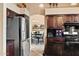 A kitchen with stainless steel appliances and dark wood cabinets with view into the dining area at 20657 N 56Th Ave, Glendale, AZ 85308