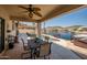 Covered patio with a ceiling fan, dining area, views of the pool, and waterfront, perfect for outdoor living at 20657 N 56Th Ave, Glendale, AZ 85308
