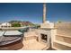 Outdoor patio features a stone fireplace, seating, and views of the lake, perfect for relaxing and entertaining guests at 20657 N 56Th Ave, Glendale, AZ 85308