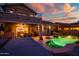 Illuminated pool area and exterior of home at dusk, with a hot tub and outdoor seating at 20657 N 56Th Ave, Glendale, AZ 85308