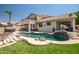 Inviting pool with rock waterfall feature, lush landscaping, and a hot tub, perfect for relaxation and entertainment at 20657 N 56Th Ave, Glendale, AZ 85308