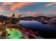 Aerial view of a backyard pool, deck, and waterfront property with a colorful sky at twilight at 20657 N 56Th Ave, Glendale, AZ 85308