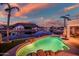 Backyard pool with rock features, a hot tub and waterfront views with palm trees and a colorful sky at 20657 N 56Th Ave, Glendale, AZ 85308