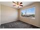 Bedroom boasting carpet floors, neutral paint, a ceiling fan and a window overlooking neighborhood views at 2134 E Broadway Rd # 2031, Tempe, AZ 85282