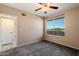 Bedroom featuring carpeted floors, neutral paint, ceiling fan and large window providing natural light at 2134 E Broadway Rd # 2031, Tempe, AZ 85282