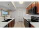Modern kitchen with stainless steel appliances, white countertops, and dark cabinets at 2134 E Broadway Rd # 2031, Tempe, AZ 85282