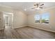 Bright living room featuring wood-look floors, neutral walls, ceiling fan and large windows with neighborhood views at 2134 E Broadway Rd # 2031, Tempe, AZ 85282