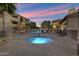 Resort-style pool and spa area with lounge chairs and lush landscaping at sunset at 2134 E Broadway Rd # 2031, Tempe, AZ 85282