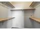 Walk-in closet featuring wood shelves, white walls and gray carpeted flooring at 2134 E Broadway Rd # 2031, Tempe, AZ 85282