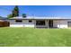 The backyard has lush green grass and features the back of the house with covered patio at 215 W Ruth Ave, Phoenix, AZ 85021