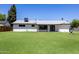 The backyard has lush green grass and features the back of the house at 215 W Ruth Ave, Phoenix, AZ 85021