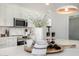 Close up of kitchen island countertop with a decorative candle, wooden tray, flowers and white cabinetry in background at 215 W Ruth Ave, Phoenix, AZ 85021