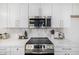 Modern kitchen with white cabinets, stainless steel appliances, tiled backsplash, and marble countertops at 215 W Ruth Ave, Phoenix, AZ 85021