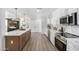 Open-concept kitchen and living area featuring modern appliances, white cabinets, and a large kitchen island with seating at 215 W Ruth Ave, Phoenix, AZ 85021