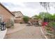 Landscaped backyard featuring stone fireplace, cozy seating area, and lush greenery, ideal for relaxation at 2221 W Calle De Las Estrella Way, Phoenix, AZ 85085