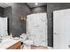 Stylish bathroom featuring unique dark grey wall, white cabinet, and marble-patterned shower curtain at 2221 W Calle De Las Estrella Way, Phoenix, AZ 85085