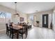 Open-concept living room with wood tile flooring, dining area, and plenty of natural light at 2221 W Calle De Las Estrella Way, Phoenix, AZ 85085