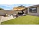 Outdoor patio with artificial turf, seating area, and well-manicured landscaping, perfect for entertaining at 22476 E Indiana Ave, Queen Creek, AZ 85142