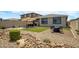 Serene backyard featuring a manicured lawn, patio seating, a rock garden, and privacy fencing at 22476 E Indiana Ave, Queen Creek, AZ 85142