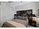 Comfortable bedroom featuring a decorative headboard, neutral tones, and ample closet space at 22476 E Indiana Ave, Queen Creek, AZ 85142