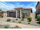 Inviting single-story home featuring a stone facade, desert landscaping, and a two-car garage at 22476 E Indiana Ave, Queen Creek, AZ 85142