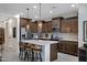 Kitchen island with breakfast bar seating and stainless steel refrigerator at 22476 E Indiana Ave, Queen Creek, AZ 85142