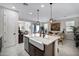 Modern kitchen island with a farmhouse sink, quartz countertop, pendant lighting, and stainless steel dishwasher at 22476 E Indiana Ave, Queen Creek, AZ 85142