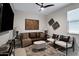 Modern living room with a brown leather sofa, stylish decor, and a ceiling fan at 22476 E Indiana Ave, Queen Creek, AZ 85142