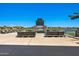 Scenic outdoor lounge area by the water featuring comfortable seating and a cozy fireplace at 22476 E Indiana Ave, Queen Creek, AZ 85142