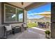 Inviting outdoor patio with comfortable seating, lush green lawn, and sunny backyard view at 22476 E Indiana Ave, Queen Creek, AZ 85142