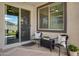 Cozy covered patio with outdoor seating and sliding glass door access to the home at 22476 E Indiana Ave, Queen Creek, AZ 85142