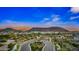 Scenic aerial view of a beautifully landscaped community with winding streets, desert landscaping, and mountain views at sunset at 2324 E Saguaro Park Ln, Phoenix, AZ 85024