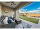 Inviting covered patio featuring stylish outdoor seating, a ceiling fan, and views of the refreshing pool and landscaped backyard at 2324 E Saguaro Park Ln, Phoenix, AZ 85024