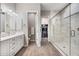 Modern bathroom featuring a double vanity, glass enclosed shower, and walk-in closet at 2324 E Saguaro Park Ln, Phoenix, AZ 85024