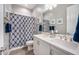 Well-lit bathroom featuring double sinks and a patterned shower curtain at 2324 E Saguaro Park Ln, Phoenix, AZ 85024