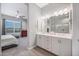 Bathroom with double sinks, storage cabinets, and a view into the bedroom at 2324 E Saguaro Park Ln, Phoenix, AZ 85024