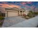Exterior of a home featuring a three-car garage, stone accents, and paved driveway at 2324 E Saguaro Park Ln, Phoenix, AZ 85024